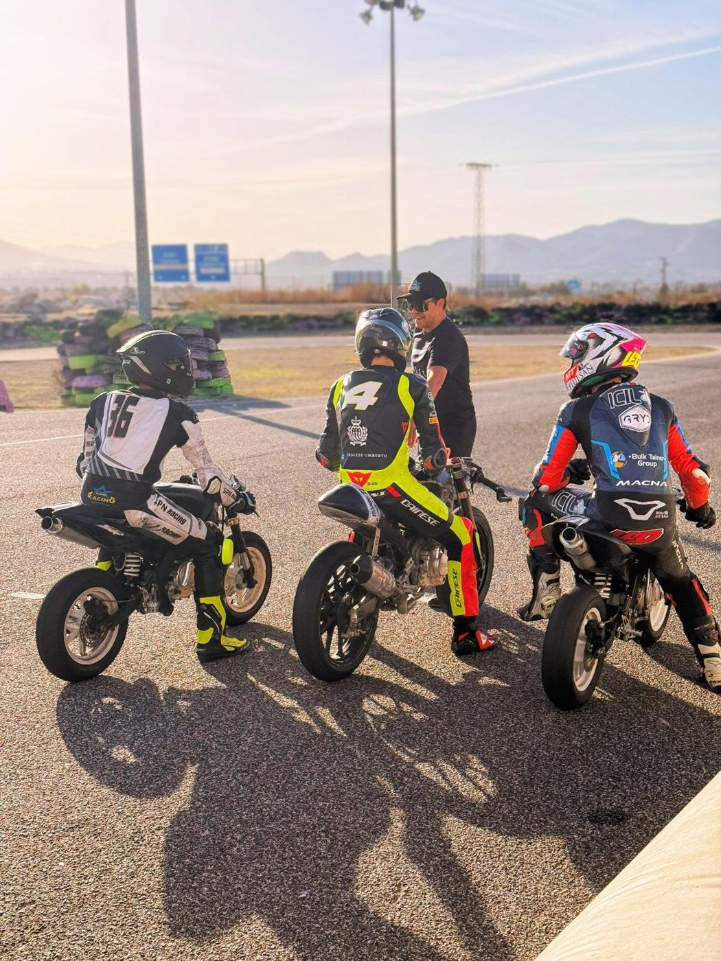 Josh, number 36, on his bike as coach Nico Ferreira briefs riders before a session.