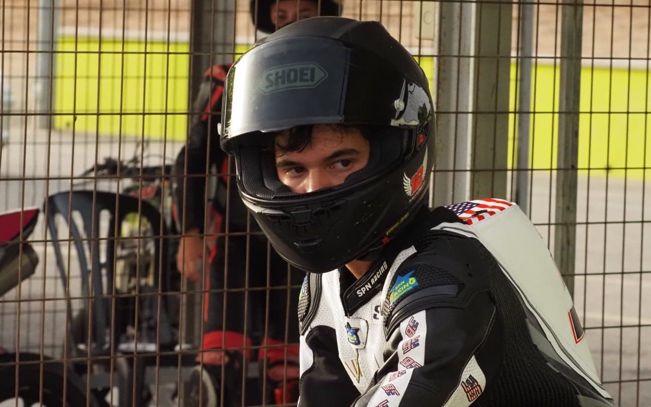 Josh in his Shoei helmet and SPN Racing leathers, looking over his shoulder in the paddock.