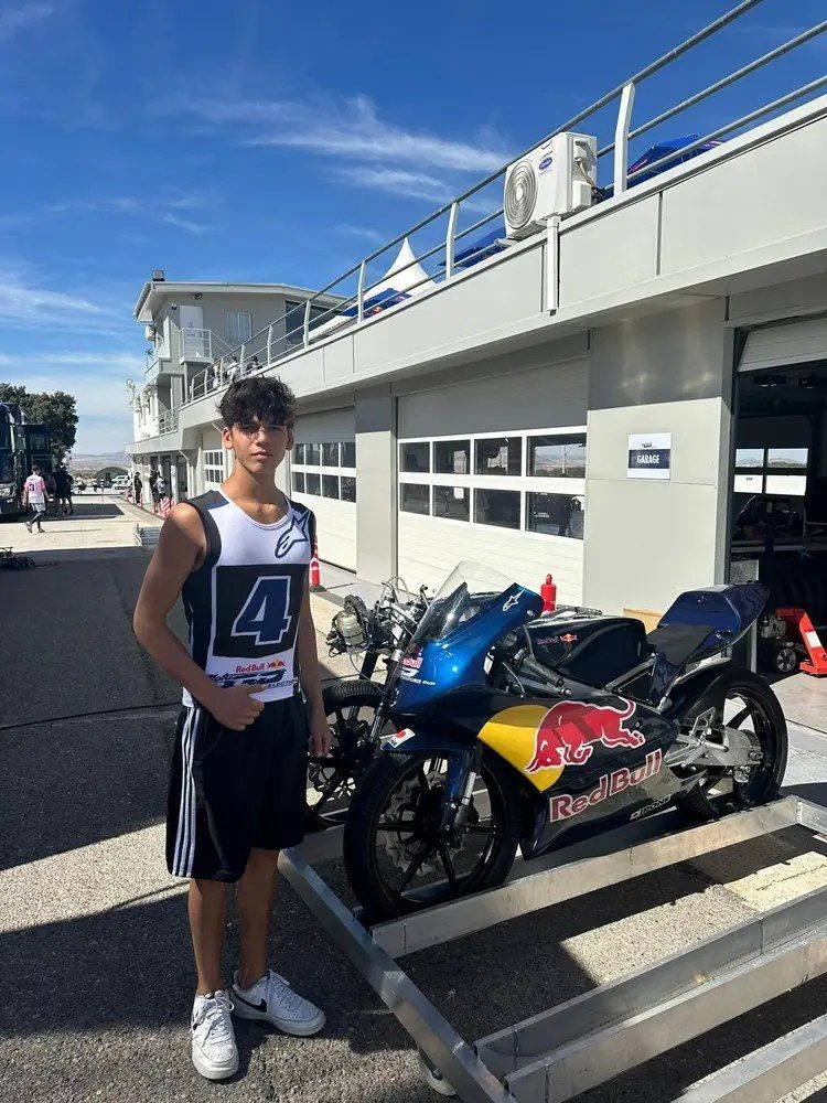Josh beside a Red Bull bike in the pit lane.