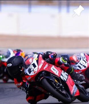Josh cornering on the red and black MIR bike, number 3.