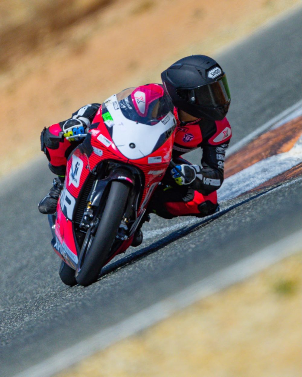 Josh leaning hard into a corner on the red MIR bike.